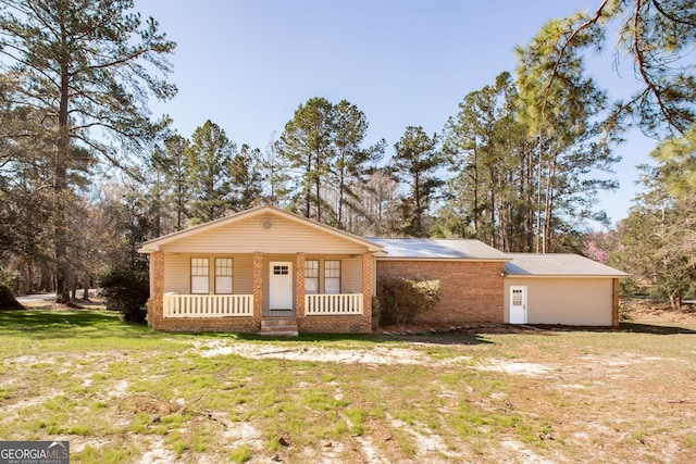 view of front of home with a porch, a front yard, and metal roof