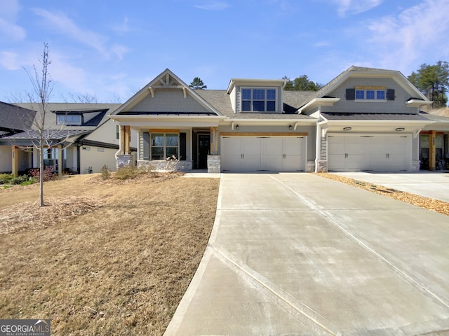 view of front facade featuring stone siding, concrete driveway, and a garage