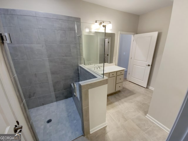 full bathroom featuring vanity, a walk in shower, and baseboards