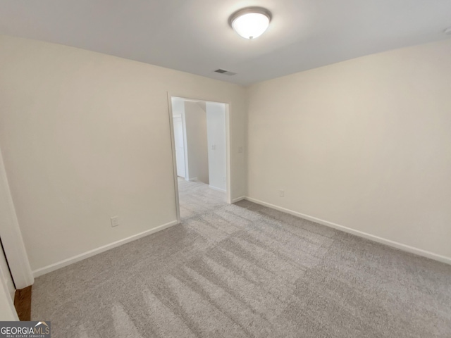 empty room with visible vents, baseboards, and carpet floors