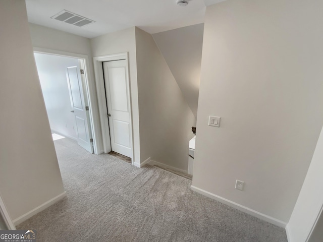 corridor featuring visible vents, carpet floors, baseboards, and an upstairs landing