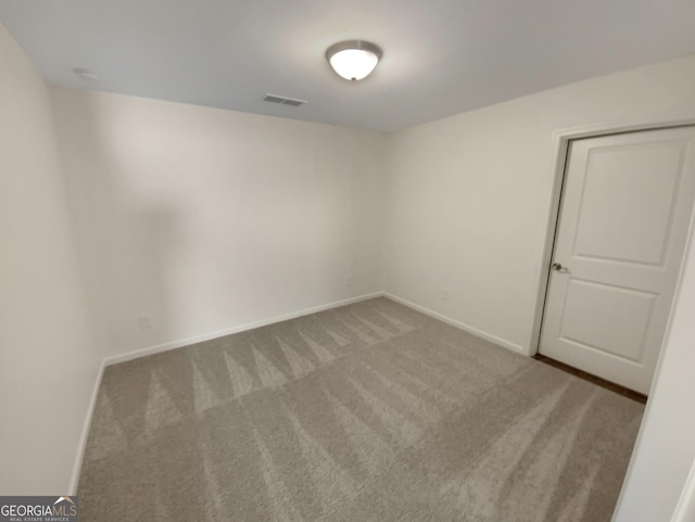 carpeted empty room with visible vents and baseboards