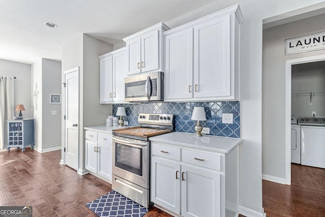 kitchen with independent washer and dryer, tasteful backsplash, dark wood finished floors, white cabinetry, and stainless steel appliances