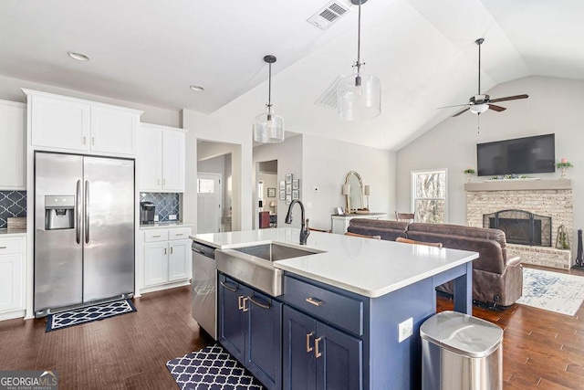 kitchen with visible vents, a sink, stainless steel appliances, white cabinetry, and blue cabinets