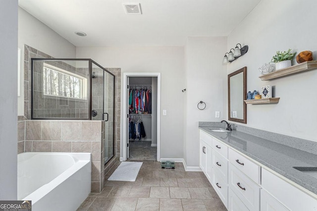 bathroom featuring visible vents, a garden tub, a stall shower, and vanity