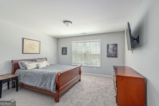 bedroom featuring visible vents, light colored carpet, and baseboards