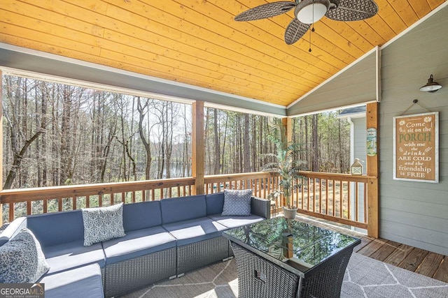 wooden deck with outdoor lounge area and a ceiling fan