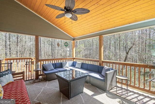 exterior space featuring an outdoor living space, a view of trees, and a ceiling fan