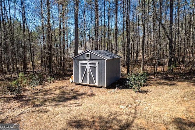 view of shed featuring a view of trees