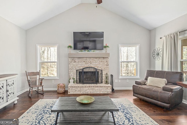 living room with a brick fireplace, wood finished floors, baseboards, and high vaulted ceiling