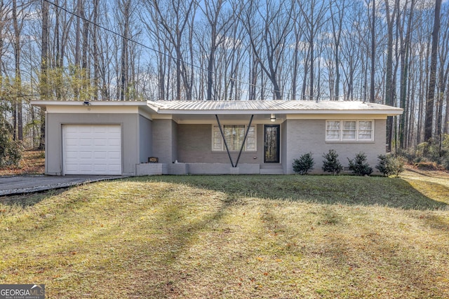 view of front of property with brick siding, aphalt driveway, a front yard, metal roof, and an attached garage