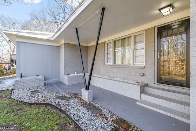 entrance to property featuring brick siding