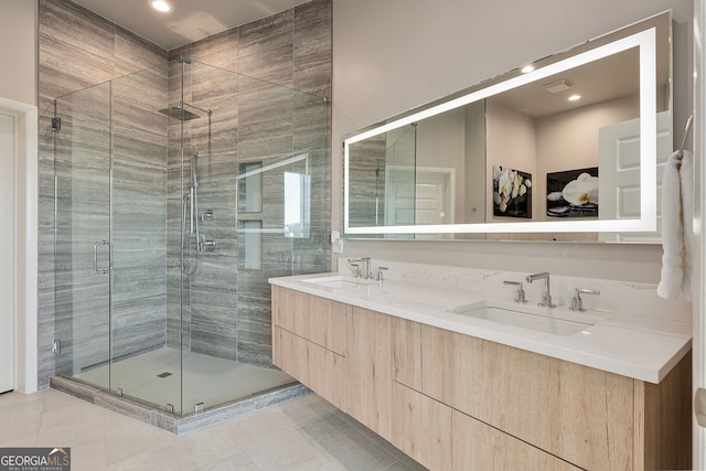 bathroom featuring double vanity, a shower stall, tile patterned floors, and a sink