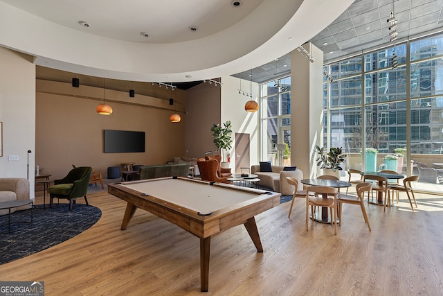 game room featuring pool table, light wood-type flooring, and a wall of windows