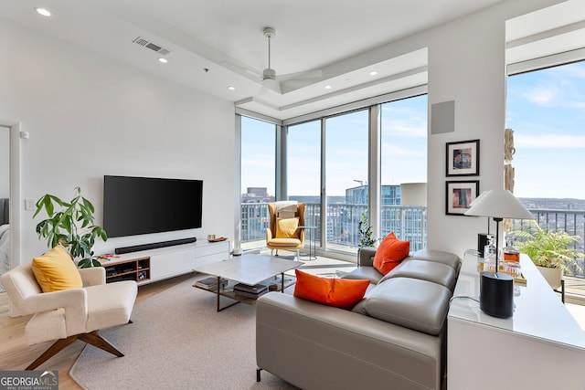 living area with visible vents, expansive windows, recessed lighting, wood finished floors, and a ceiling fan