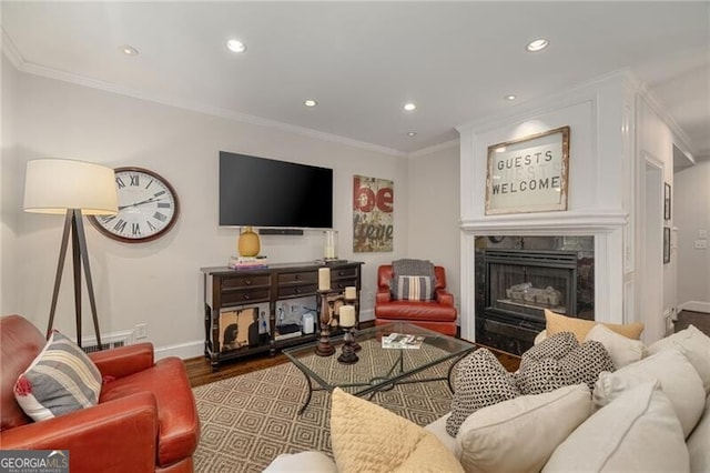 living room featuring crown molding, baseboards, a premium fireplace, recessed lighting, and wood finished floors