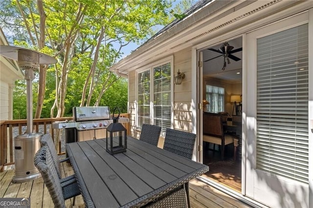 wooden terrace with outdoor dining area and grilling area