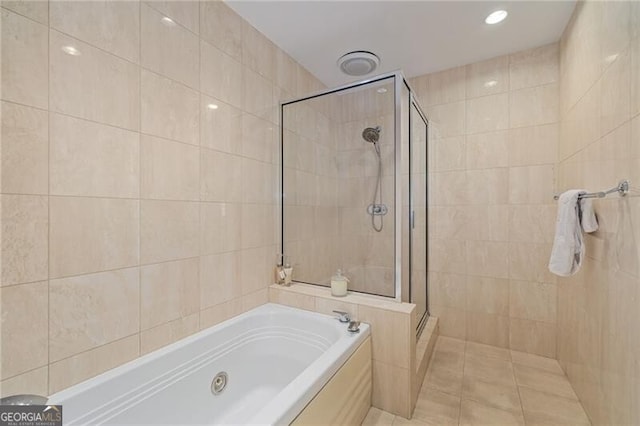 full bath with a stall shower, tile walls, and a garden tub