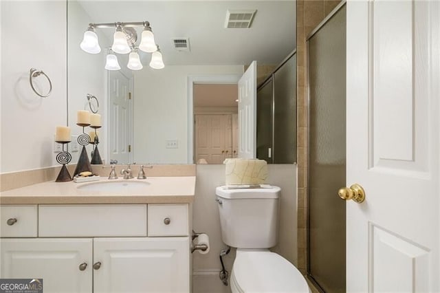 bathroom featuring vanity, a shower stall, toilet, and visible vents