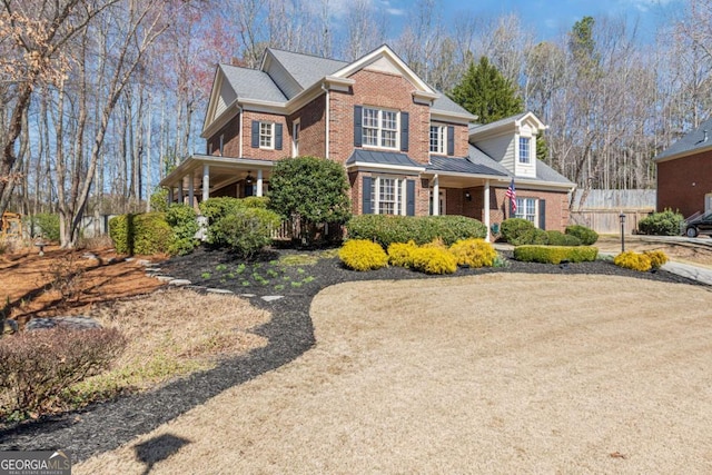 view of front of house featuring fence and brick siding