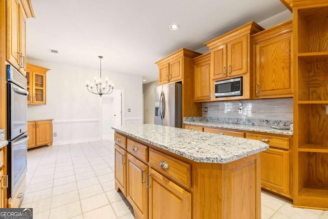 kitchen with tasteful backsplash, light stone countertops, a chandelier, stainless steel appliances, and open shelves