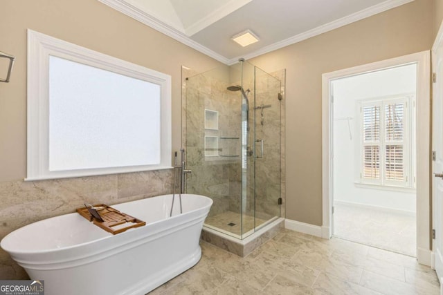 bathroom featuring a shower stall, baseboards, ornamental molding, a freestanding tub, and tile walls