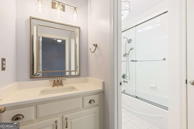 full bath featuring vanity, bath / shower combo with glass door, and tile patterned flooring