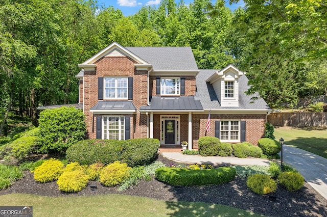 view of front of property with brick siding and fence
