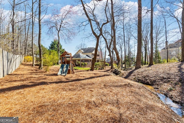 view of yard with playground community and fence