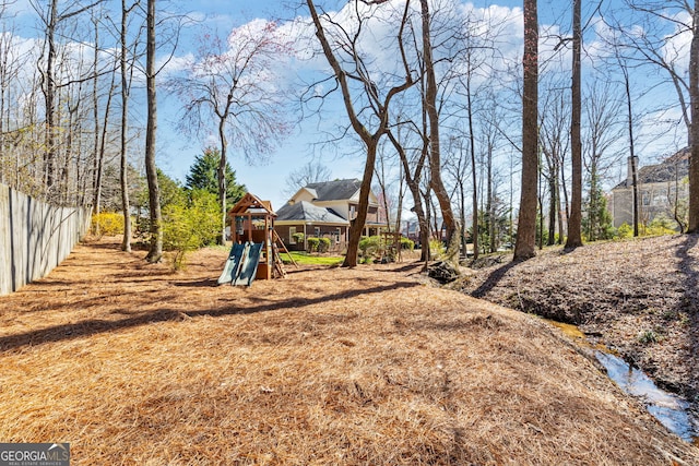 view of yard featuring a playground and fence