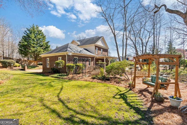 exterior space with brick siding, a lawn, and a pergola