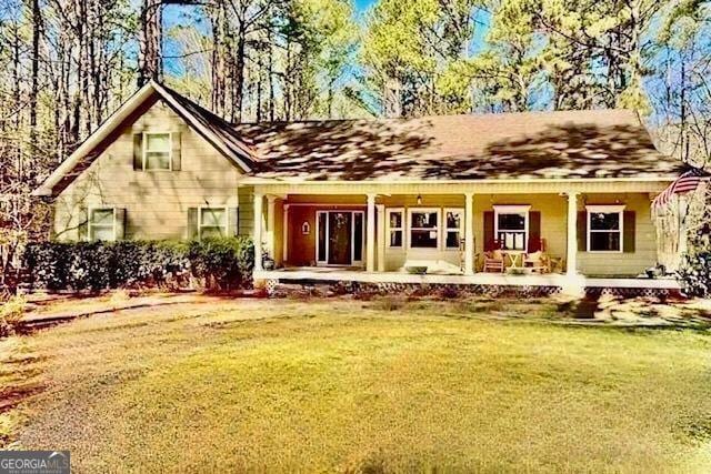 rear view of property featuring a lawn