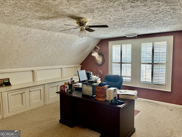 office space featuring a ceiling fan, lofted ceiling, light colored carpet, and a textured ceiling