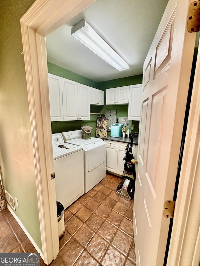 washroom featuring cabinet space and washer and clothes dryer