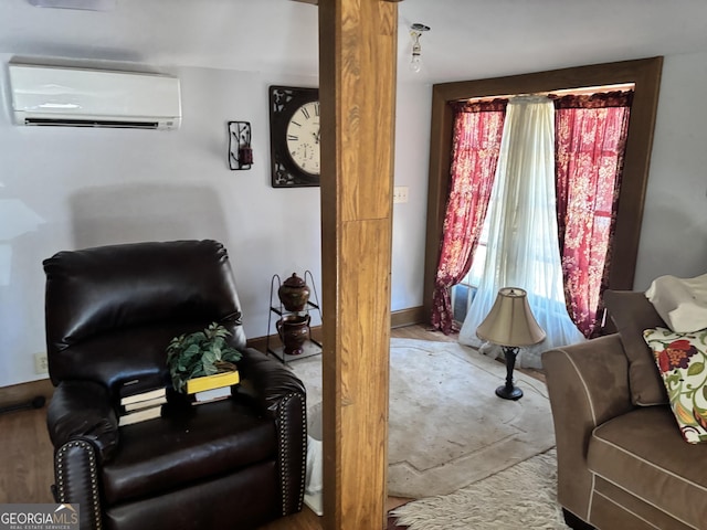 sitting room with a wall mounted air conditioner and ornate columns