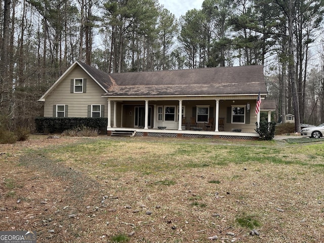 view of front of home with a porch, a front lawn, and a shingled roof