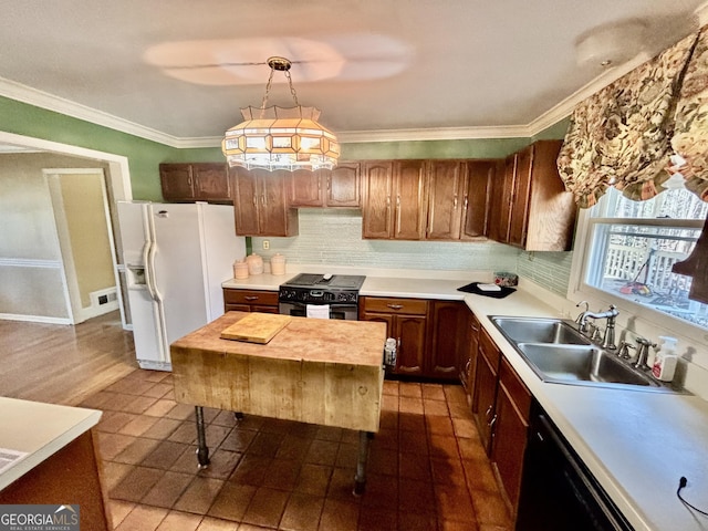 kitchen with a sink, black appliances, crown molding, and light countertops