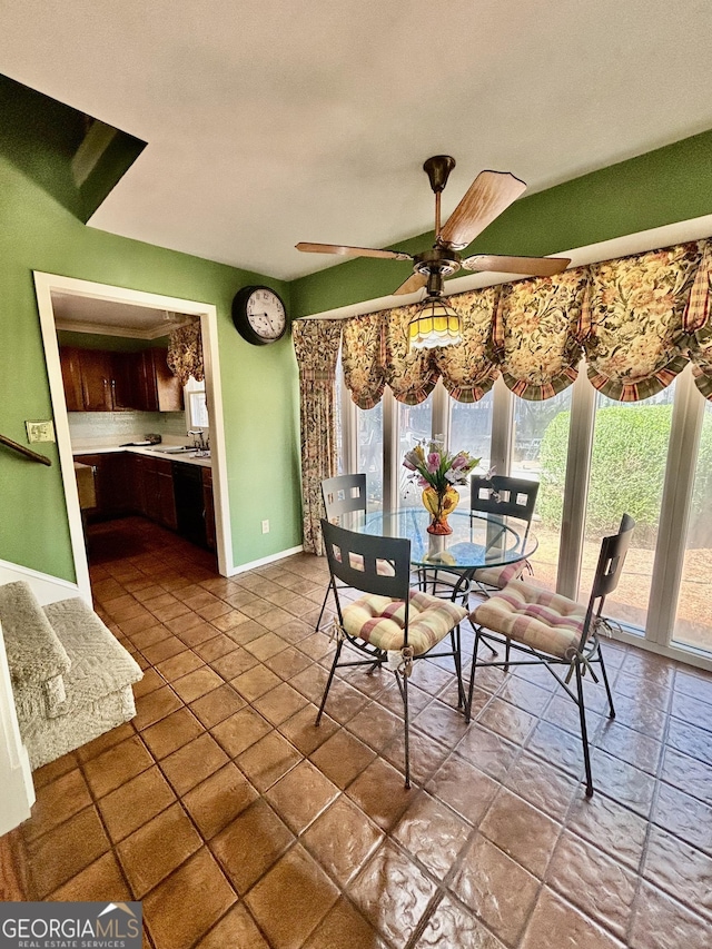 dining space with a ceiling fan and baseboards