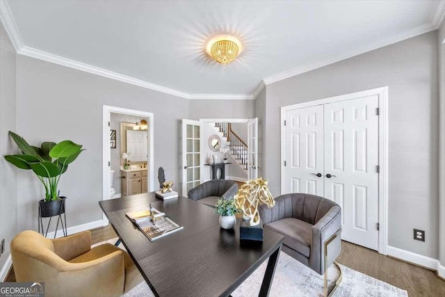 office area with baseboards, wood finished floors, and ornamental molding