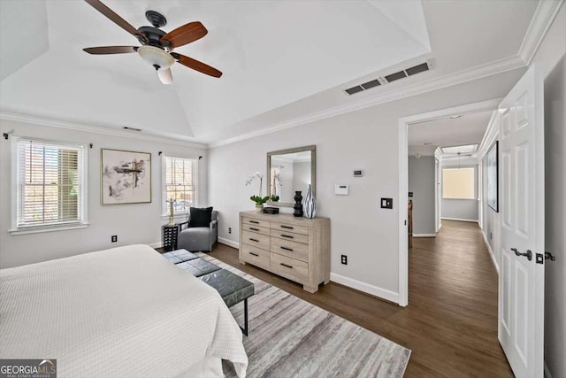 bedroom with wood finished floors, visible vents, baseboards, lofted ceiling, and crown molding