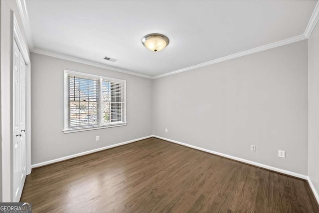 unfurnished bedroom with visible vents, dark wood-type flooring, baseboards, and ornamental molding