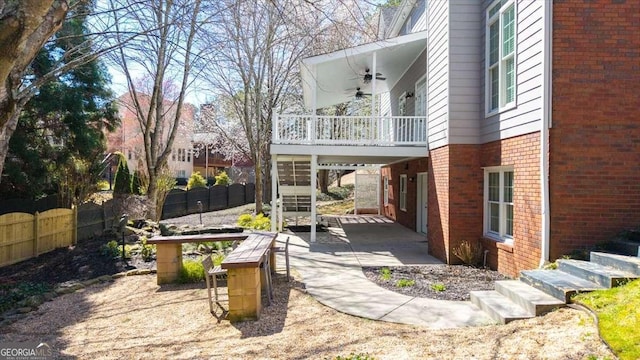 view of patio featuring stairs, a ceiling fan, and fence