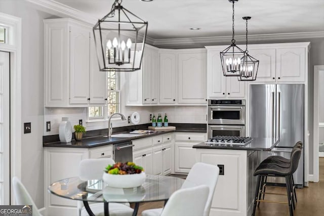 kitchen featuring a chandelier, white cabinets, stainless steel appliances, and backsplash