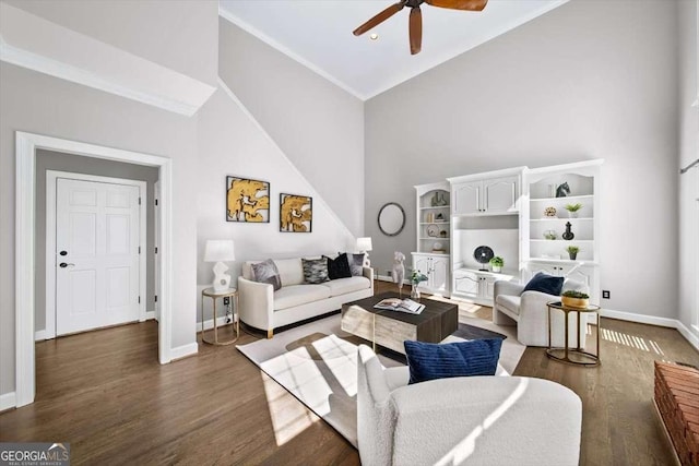 living area featuring baseboards, high vaulted ceiling, wood finished floors, and a ceiling fan