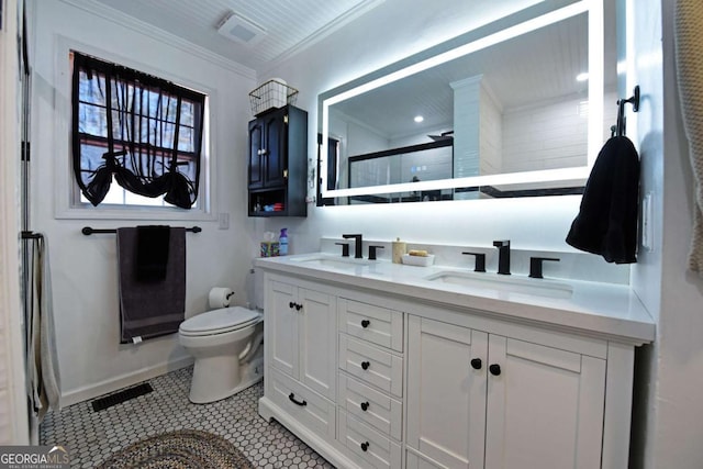 bathroom with ornamental molding, toilet, a shower stall, and a sink