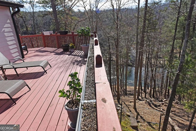 wooden deck with a wooded view