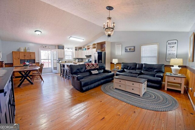 106 Opaque Way, Ellijay, GA 30540 - living area with lofted ceiling, a textured ceiling, light wood-type flooring, and a chandelier