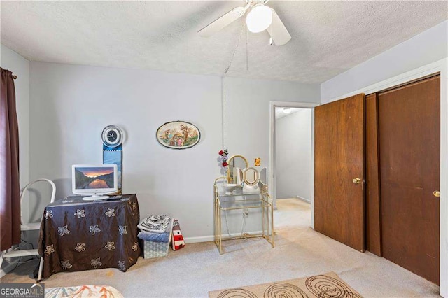 carpeted bedroom featuring a closet, a textured ceiling, and a ceiling fan