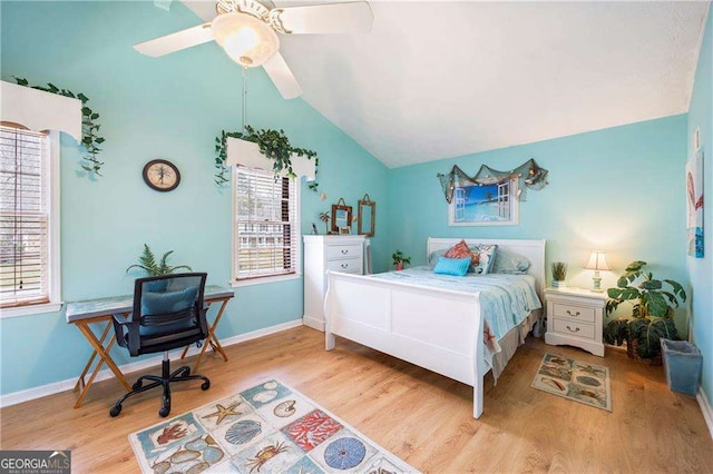 bedroom with baseboards, multiple windows, light wood-style flooring, and vaulted ceiling