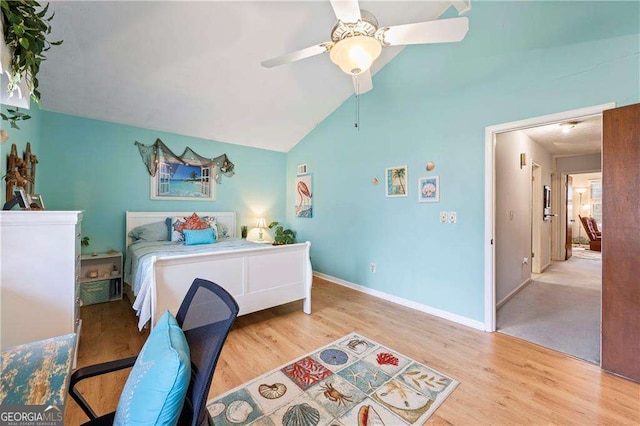 bedroom featuring baseboards, lofted ceiling, wood finished floors, and a ceiling fan